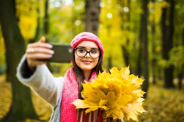 Junge Frau mit Herbstblättern vor Selfie — Stockfoto