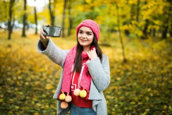Frau macht Selfie im Herbstpark. — Stockfoto