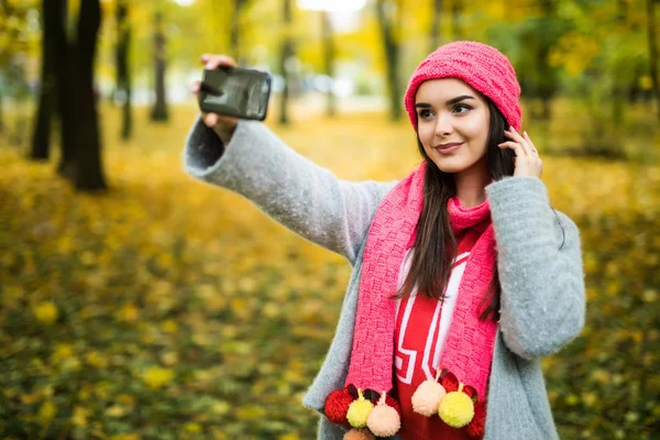Kobieta robi selfie w jesienny park. — Zdjęcie stockowe