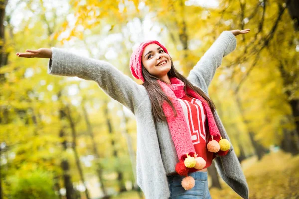 Frau geht im Herbstpark spazieren. hebt die Hände. — Stockfoto