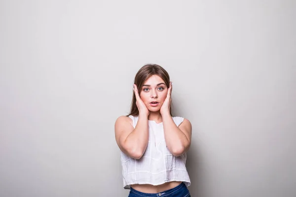 Chica cerrar las orejas con las manos sobre un fondo gris — Foto de Stock