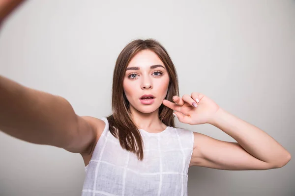 Jeune fille faire selfie sur un fond gris — Photo