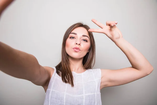 Jeune fille faire selfie sur un fond gris — Photo