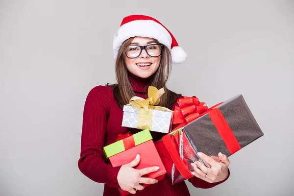 Donna con cappello di Natale tenere molti regalo di Natale — Foto Stock