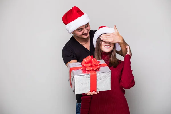 Ung man innehar en presentbox medan hennes flickvän — Stockfoto