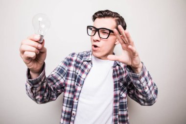 Gözlüklü küçük ampul tutan genç adam