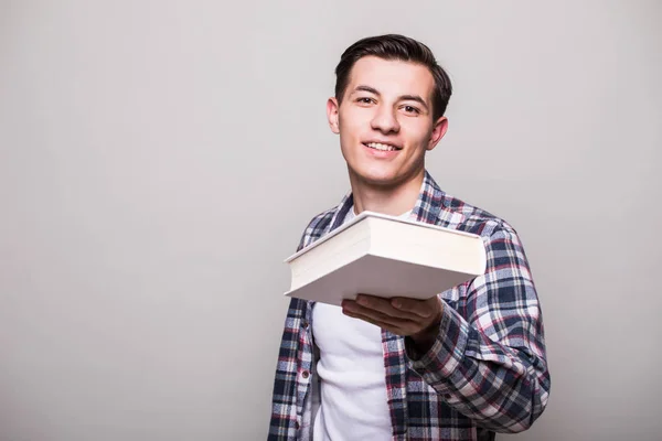 Молодой человек в костюме держит книгу и показывает большой палец на белом фоне — стоковое фото
