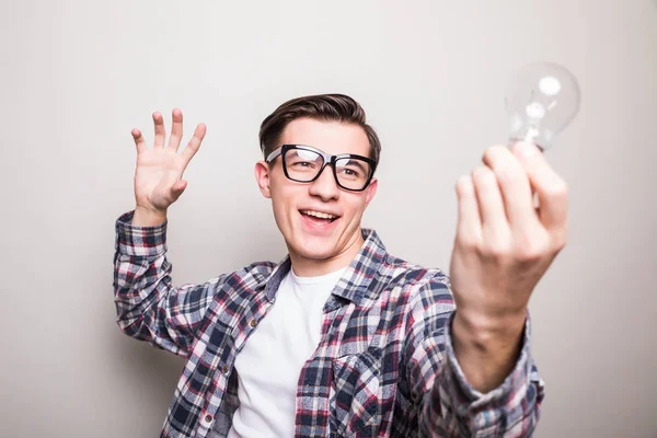 Jovem homem em óculos segurando pequena lâmpada — Fotografia de Stock