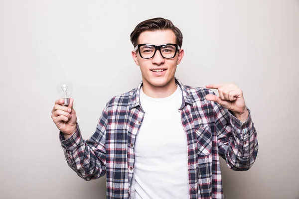 Jovem homem em óculos segurando pequena lâmpada — Fotografia de Stock