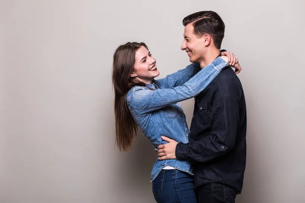 Pareja abrazándose sobre fondo gris — Foto de Stock