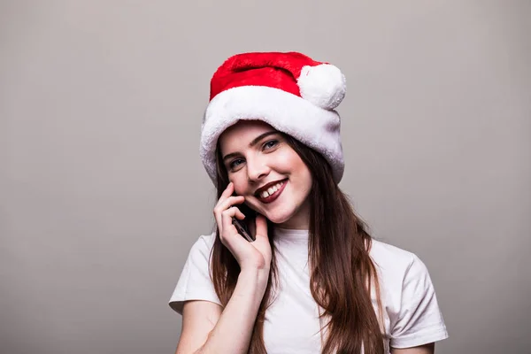 Lachende meisje met KERSTMUTS bellen op telefoon. — Stockfoto