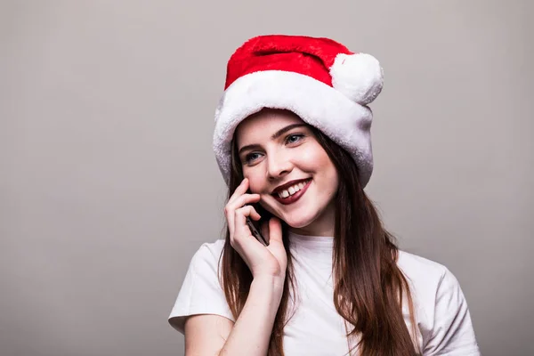 Lachende meisje met KERSTMUTS bellen op telefoon. — Stockfoto