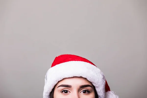 Ojos de chica en sombrero de santa sobre fondo gris —  Fotos de Stock