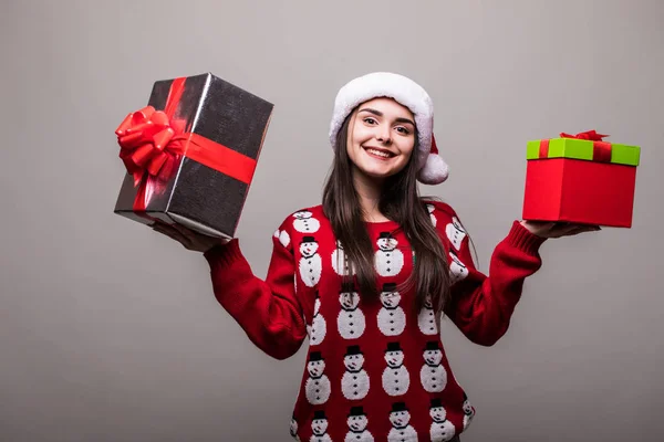 Hediye kutuları olan kadın. Güzel esmer kız kazak ve Noel Baba şapkası giyiyor izole. — Stok fotoğraf