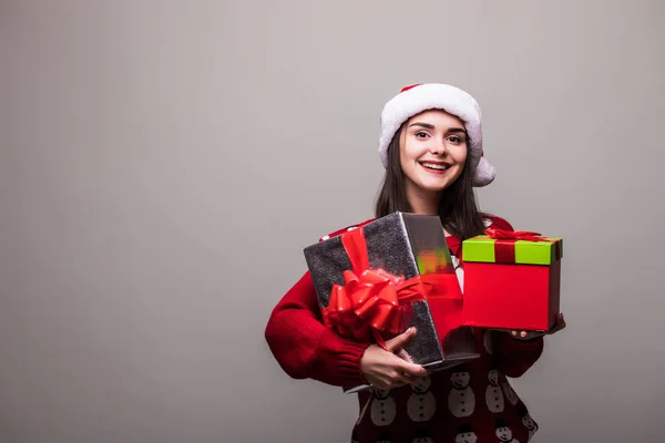Жінка з подарункові коробки. Красива дівчина брюнетка, одягнений у светр і шапочка Санта ізольовані. Портрет — стокове фото
