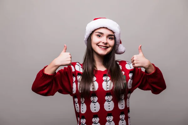 Meisje model dragen santa hat en christmas sweater met okey gebaar op grijze achtergrond — Stockfoto