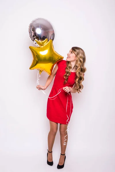 Mujer joven con globo de oro y plata sonriendo aislada en blanco —  Fotos de Stock