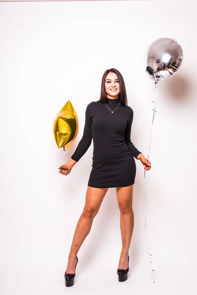 Ganska ung kvinna i svart klänning med guld stjärna formad ballong leende och dricka champagne — Stockfoto
