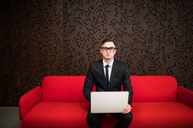 Genç işadamı ile dizüstü bilgisayar Ofis Binası'nda çalışma