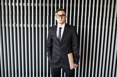 Office duvara elbiseli genç işadamı