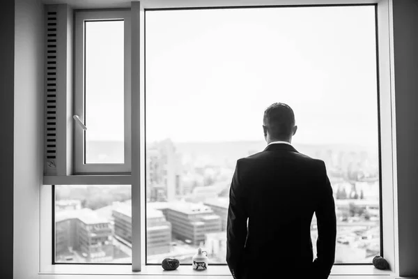 Jeune homme d'affaires regarder par la fenêtre à son bureau — Photo