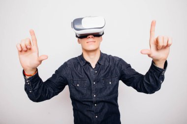 Genç adam beyaz arka plan üzerinde izole bir Vr kulaklık aracılığıyla sanal gerçeklik yaşıyor