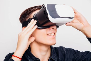 Genç adam beyaz arka plan üzerinde izole bir Vr kulaklık aracılığıyla sanal gerçeklik yaşıyor