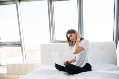 Kadın ayakları üstünde laptop ile yatakta