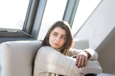 Kadın yatakta rahatça oturuyor.