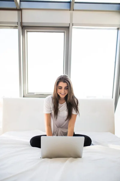 Ładna kobieta za pomocą jej laptopie w łóżku rano — Zdjęcie stockowe