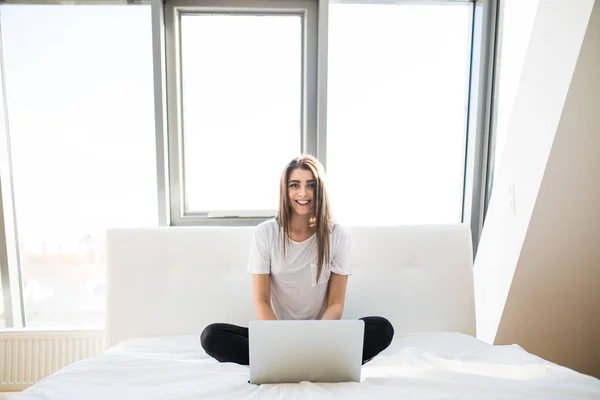 Ładna kobieta za pomocą jej laptopie w łóżku rano — Zdjęcie stockowe