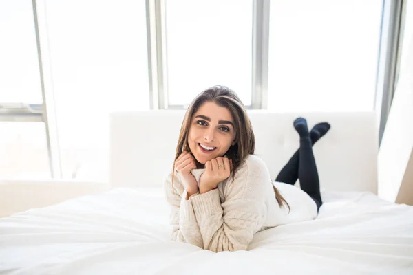 Schöne Frau auf weißem Bett liegend — Stockfoto