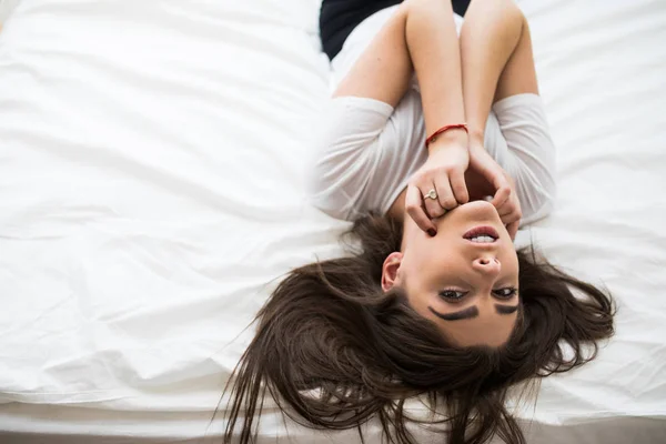 Acima vista de bonita fêmea deitada na cama — Fotografia de Stock