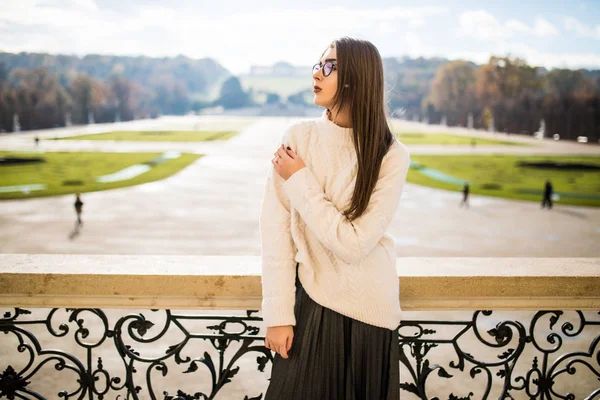 Hermosa mujer joven en el balcón de la casa en el fondo del parque — Foto de Stock