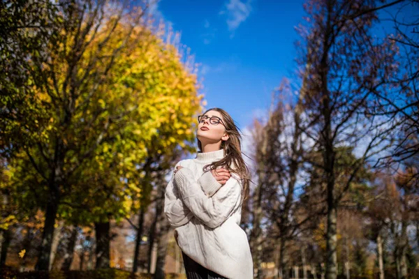 Mädchen spaziert in windigem Herbstpark über blauen Himmel — Stockfoto