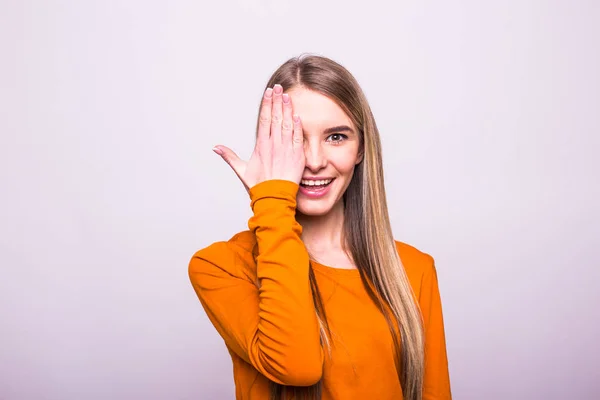 Chica rubia feliz en camiseta naranja cerrar los ojos con la mano en blanco —  Fotos de Stock
