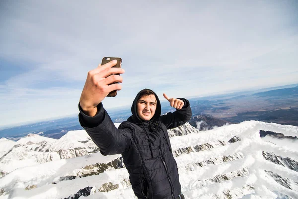 Young man take selfie in Winter in High Tatras Mountains. High Tatry. Slovakia. Vysoke Tatry. — Stock Photo, Image