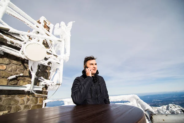 Jovem fala ao telefone no topo High Tatras Mountains. Tatry Alto. Eslováquia. Tatry Vysoke . — Fotografia de Stock