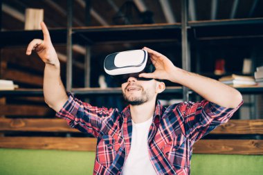 Sanal gerçeklik giyen sakallı genç adam modern coworking studio gözlükler.