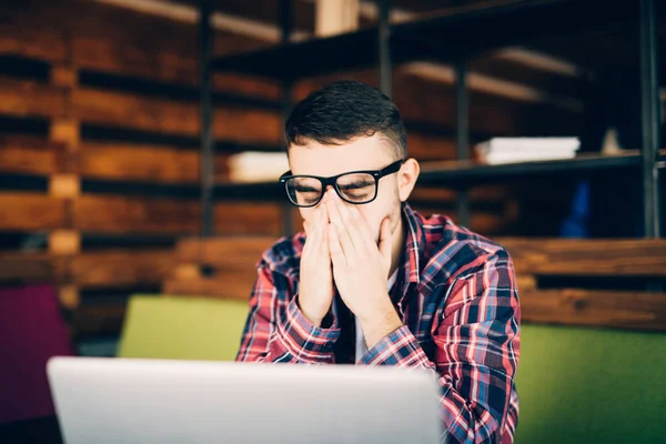 Über den müden jungen Mann im Amt. Zu viel Arbeit. — Stockfoto