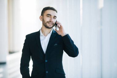 Takım elbiseli yakışıklı işadamı konuşmak vasıl yazıhane telefon