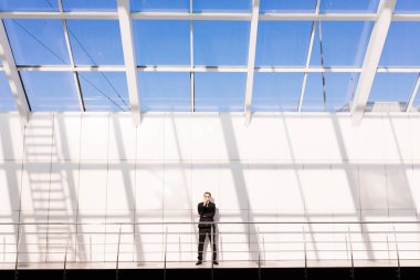 Patron. Yakışıklı genç adam ayakta modern ofis binası ise tam takım