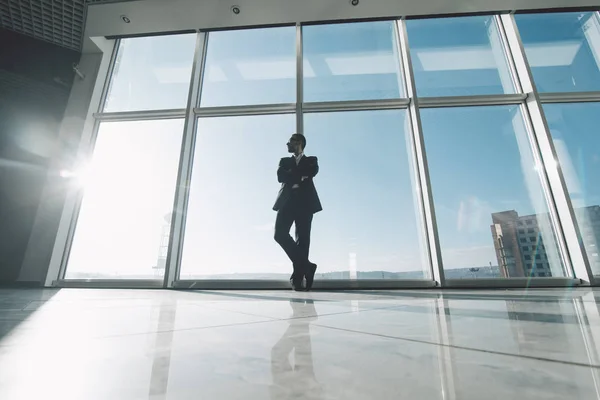 Re del mercato. Giovane uomo d'affari successo in piedi soddisfare contro finestre panoramiche — Foto Stock
