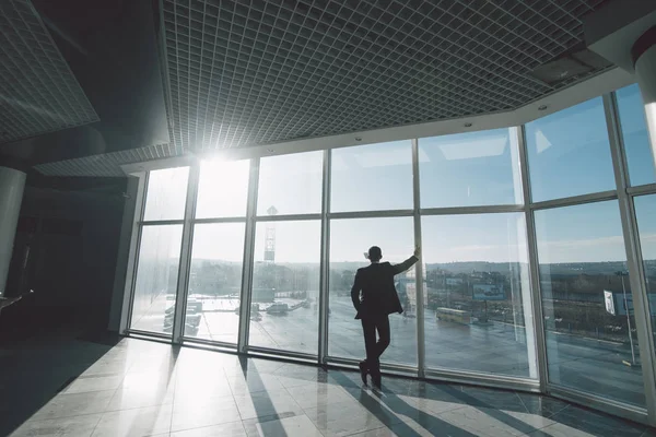 Tid att tänka. Affärsman som ensam i rum med panoramafönster. — Stockfoto