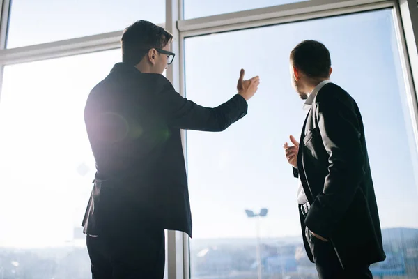 Deux hommes d'affaires dictant les plans d'affaires futurs de la construction et du développement dans le bureau — Photo