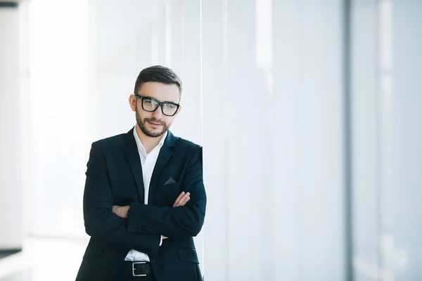 Pohledný podnikatel v obleku a brýle na pozadí windows — Stock fotografie