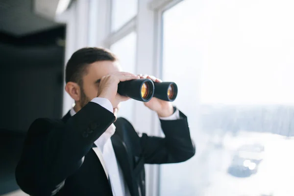 Geschäftsmann mit Fernglas spioniert Konkurrenten aus. — Stockfoto