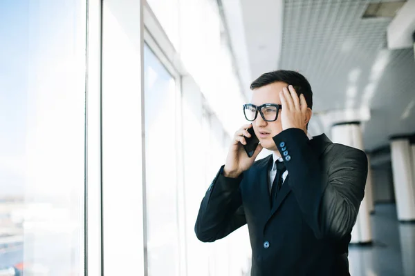 Mladý podnikatel hovoří telefon se zlobit, v úřadu — Stock fotografie