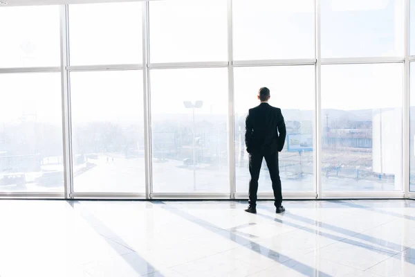 Sihluette av ung affärsman mot stora panoramafönster — Stockfoto