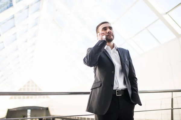 Affärsman talar på telefon och promenader runt kontoret — Stockfoto